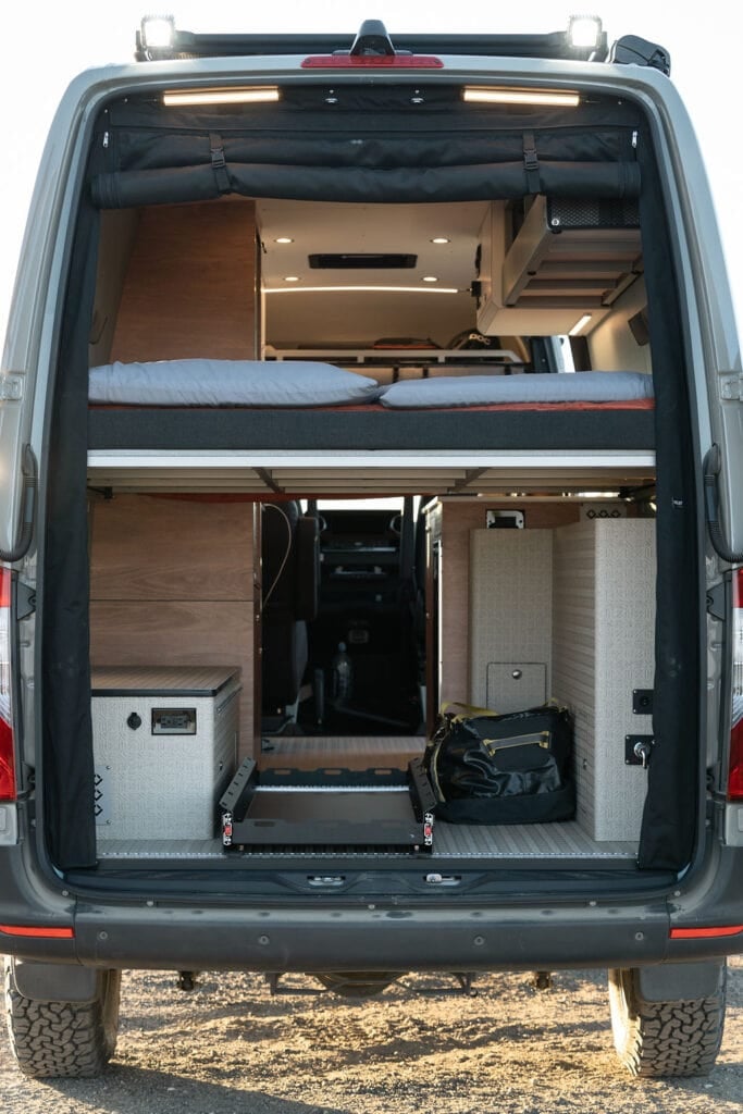 The garage area underneath the bed in a 170" 4x4 Sprinter Van conversion built for outdoor adventure