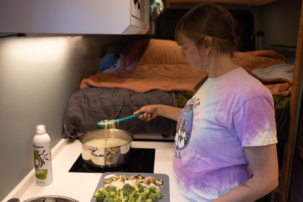 Large galley with an induction stove in a 170" sprinter van conversion built by Outside Van