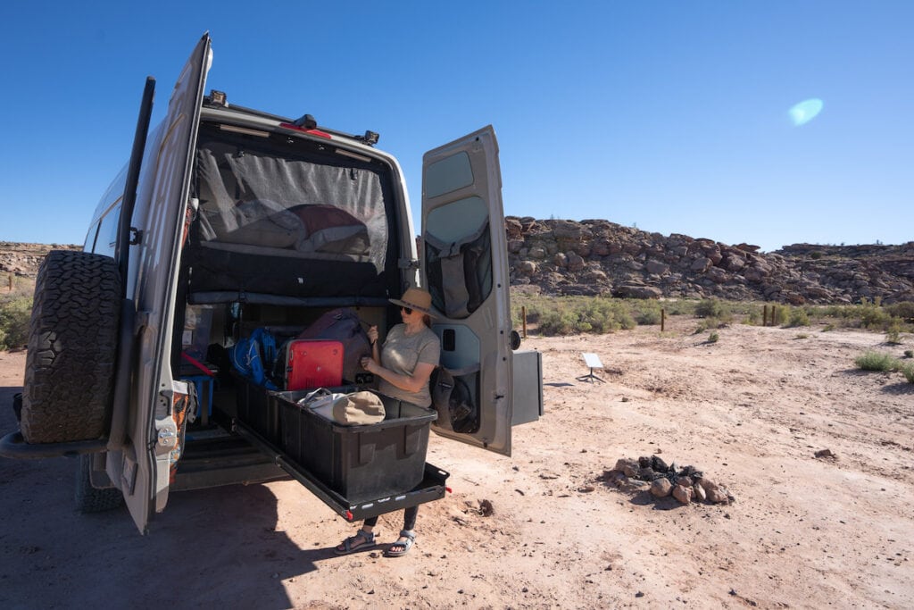 Gear organization and a gear slider in the garage of a 170" 4x4 Sprinter Van conversion built for outdoor adventure