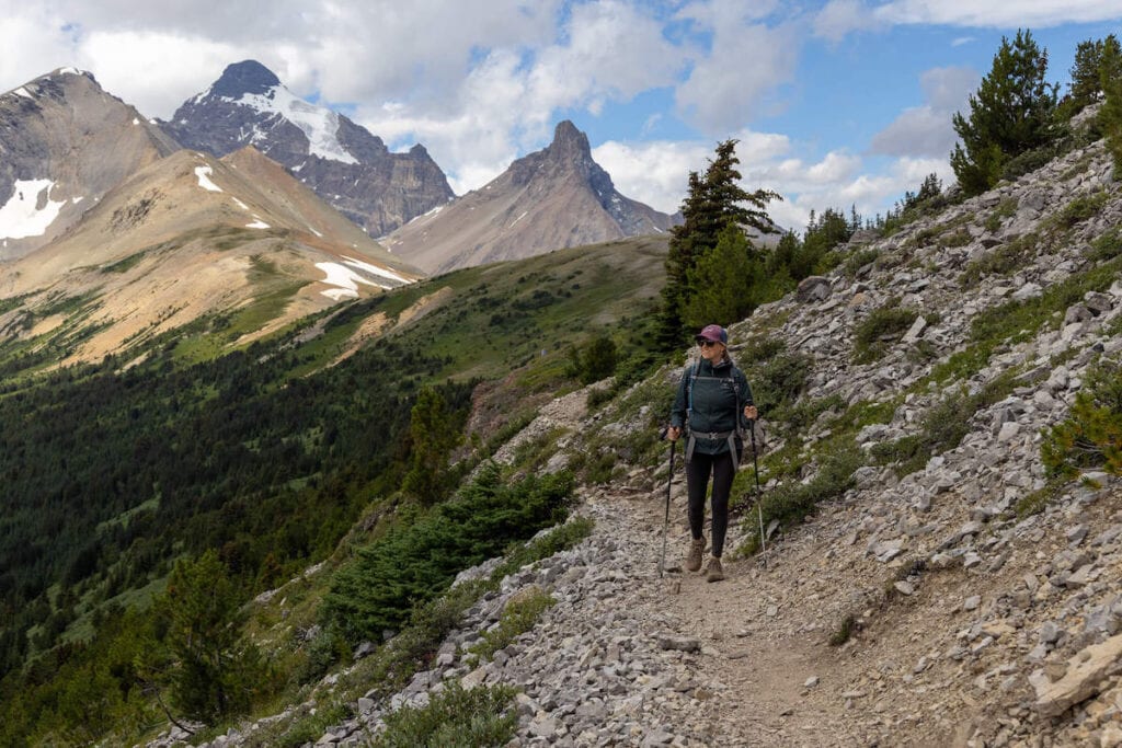 Kristen hiking on Parker Ridge Trail in Alberta with towering mountain peaks in background