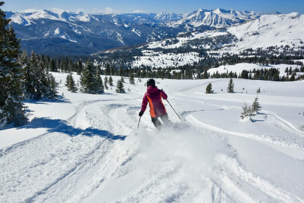 Skier skiing down snowy slopes at Crested Butte Ski Resort in Colorado