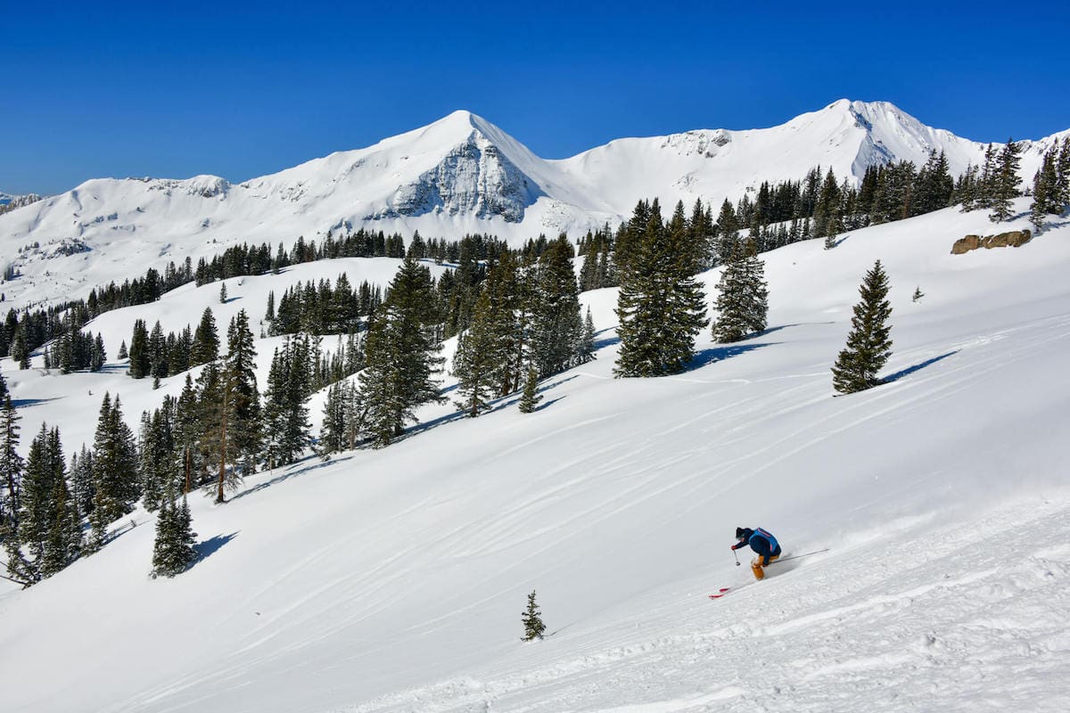 Man skiing down snowy slopes at Crested Butte Ski resort in Colorado