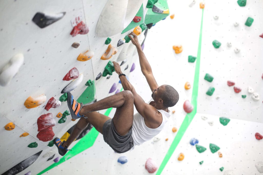 Man bouldering on indoor climbing wall 