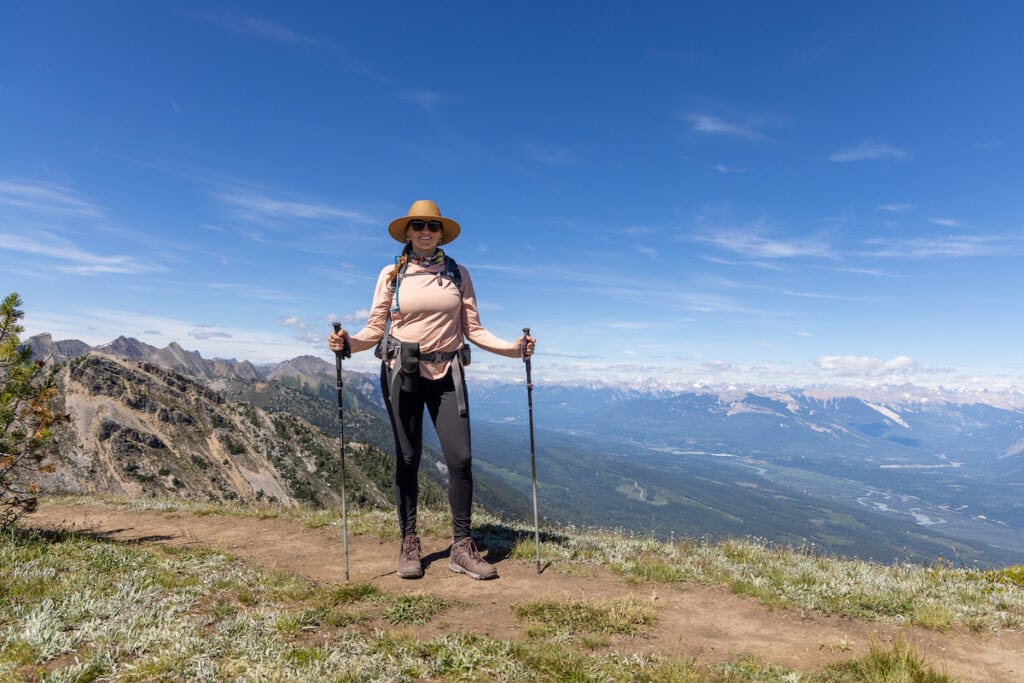 A woman smiles at the camera wearing the REI Co op Sahara Shade Hoodie in British Columbia