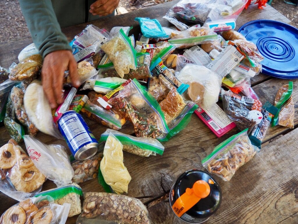 Backpacking supplies laid out on a table in Ziploc tons on the John Muir Trail