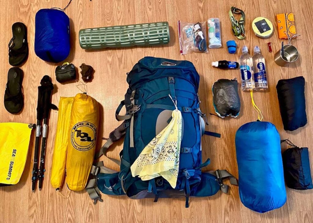 Ultralight backpacking gear laid out on wood floor in preparation for a trip