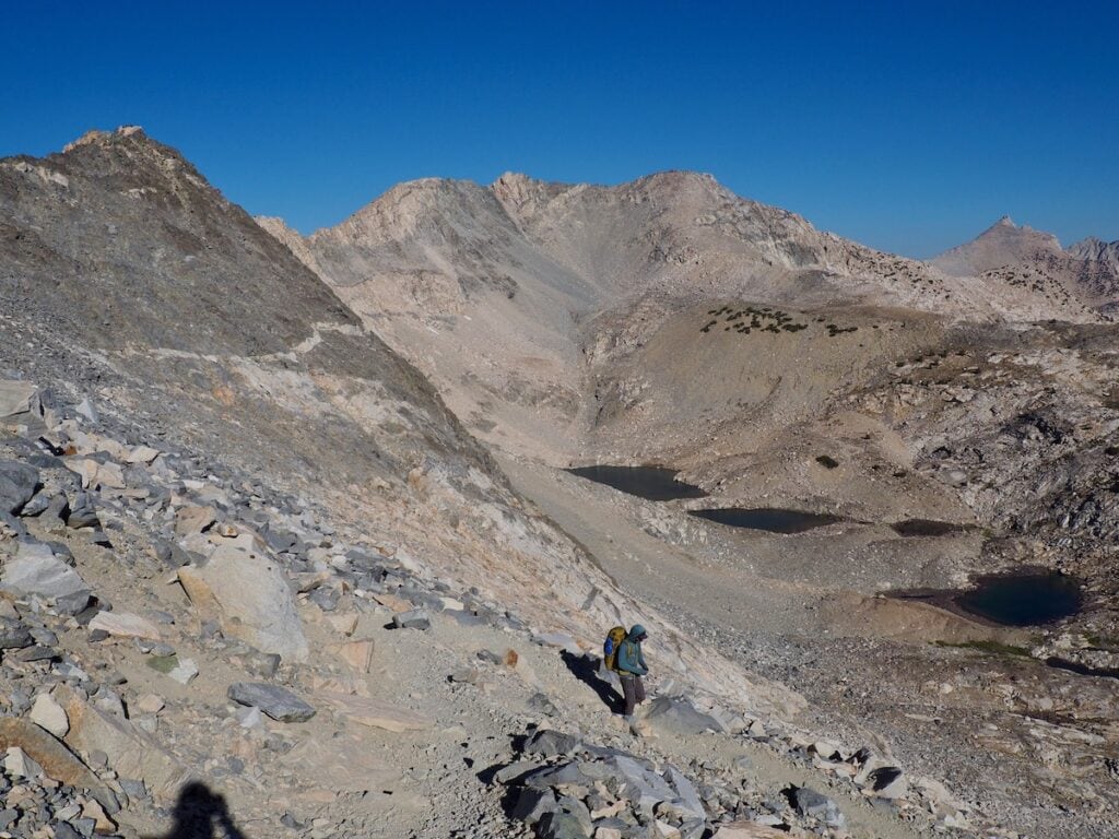 A man hikes lanugo Glen Pass on the JMT