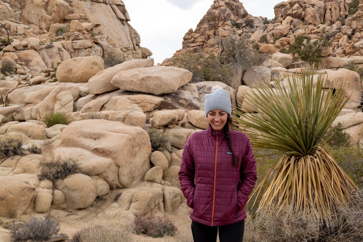 A woman wearing the Patagonia Nano Puff jacket hiking in Joshua Tree