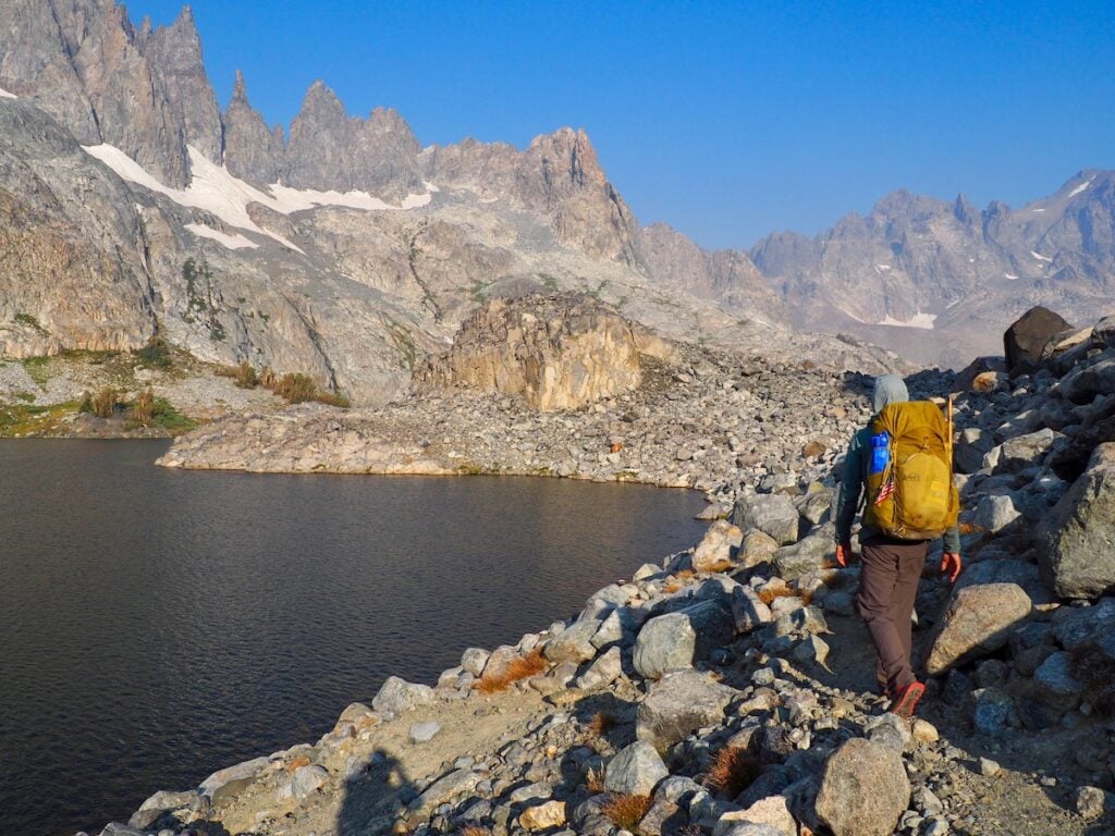 Minaret Lake on the John Muir Trail. A man hikes on a rocky path above the lake