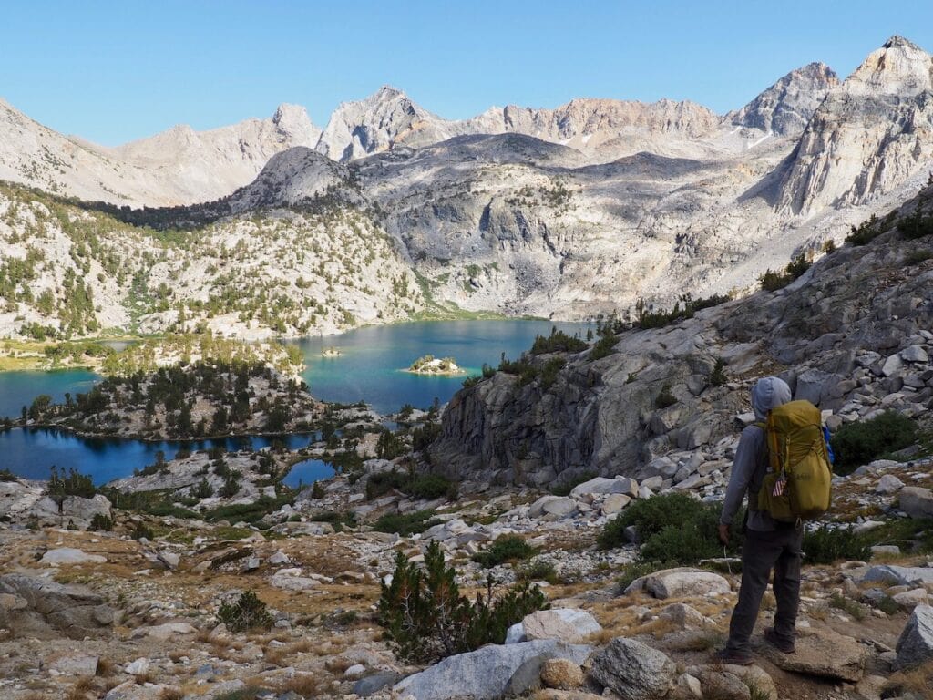 A man looks down over Rae Lakes from the Sixty Lakes Basin Trail