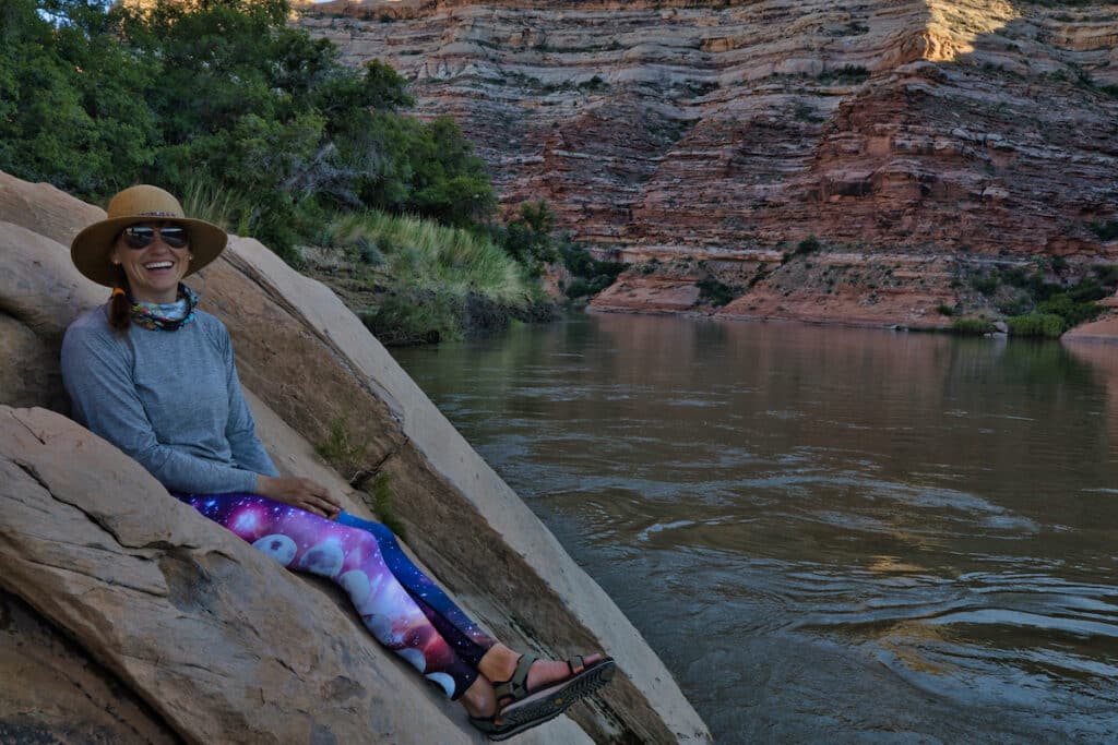 Bearfoot Theory Founder Kristen sitting on a rock in labryinth canyon with her Teva sandals on