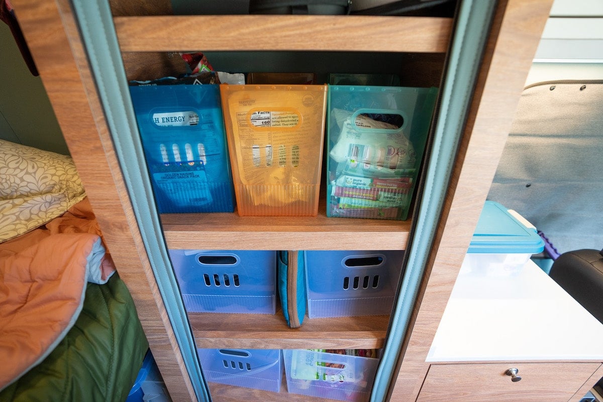 Colored plastic bins from the container store in the closet of a Sprinter Van