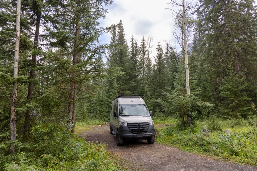 Sprinter Van camped at a forested site at Mount Kerkeslin Campground