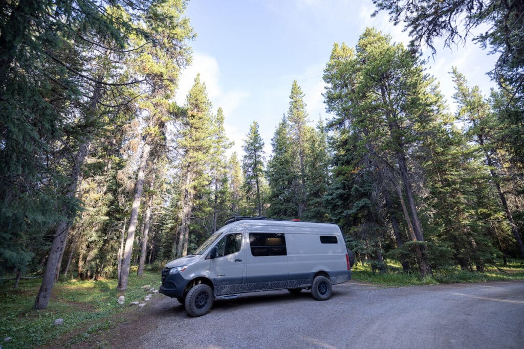 Sprinter Van in a spacious campsite at Mosquito Creek Campground in Banff National Park surrounded by trees