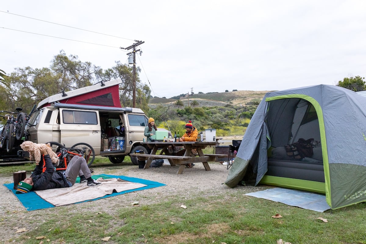 A family car camping setup with a tent and VW van