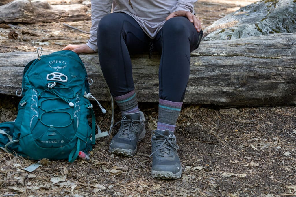 Closeup of woman hiker wearing the Oboz Katabatic hiking shoes sitting on a log during a hike