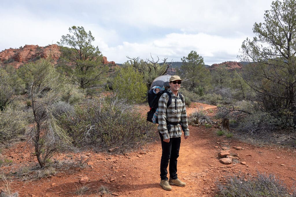 Man hiking in Red Rock State Park in Arizona carrying a baby in the Osprey Poco LT child carrier