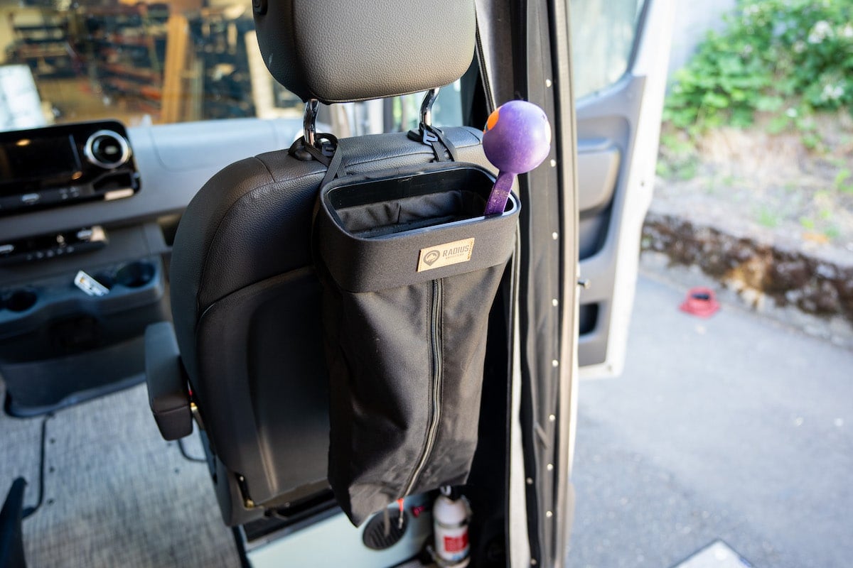 Radius Outfitters small trash tube on the back of a passenger seat in a Sprinter Van with dog gear inside