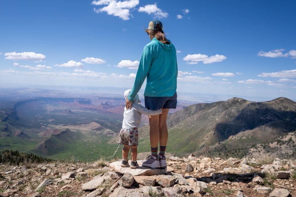 Kristen Bor standing on the top of a mountain with her son