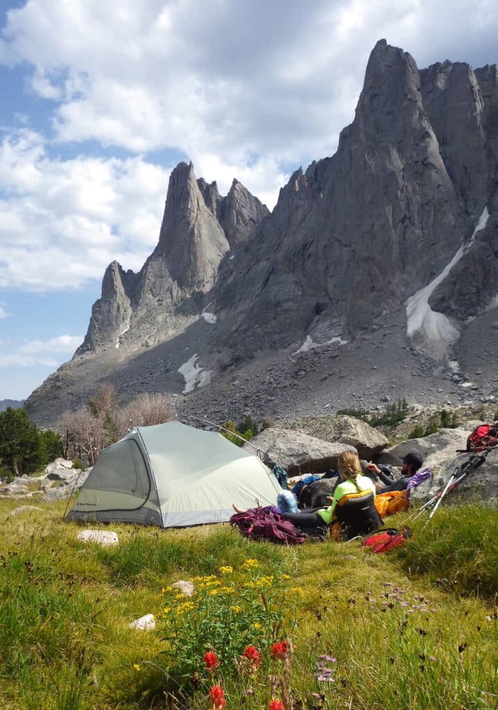 two backpackers sitting outside of a tent in Cirque of the Towers Wyoming
