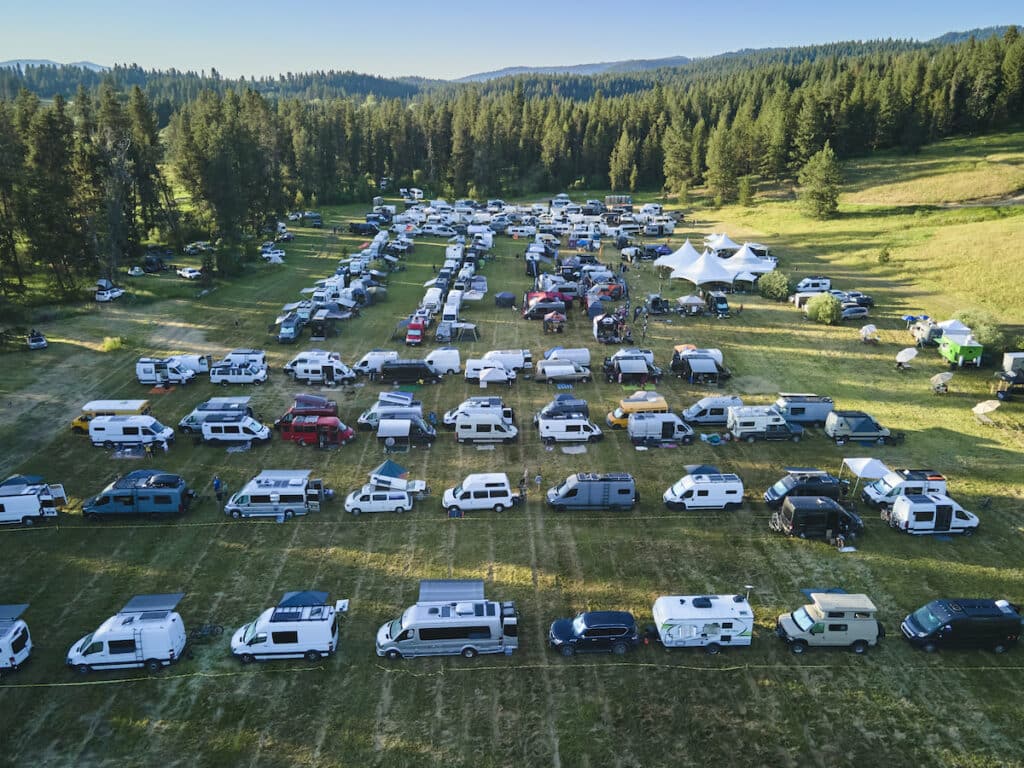 Hundreds of camper vans in a grassy field at Open Roads Festival in McCall Idaho