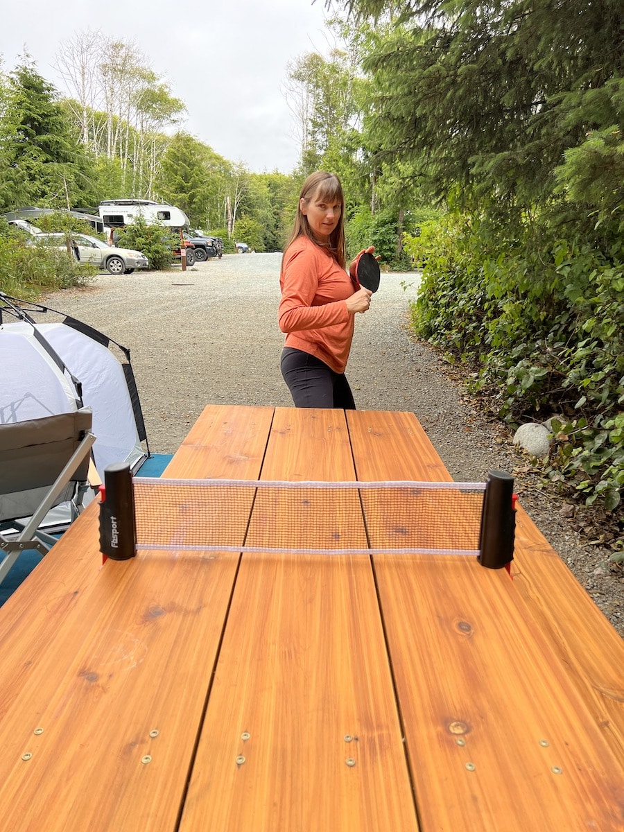 Woman playing table top ping pong while camping at a campground