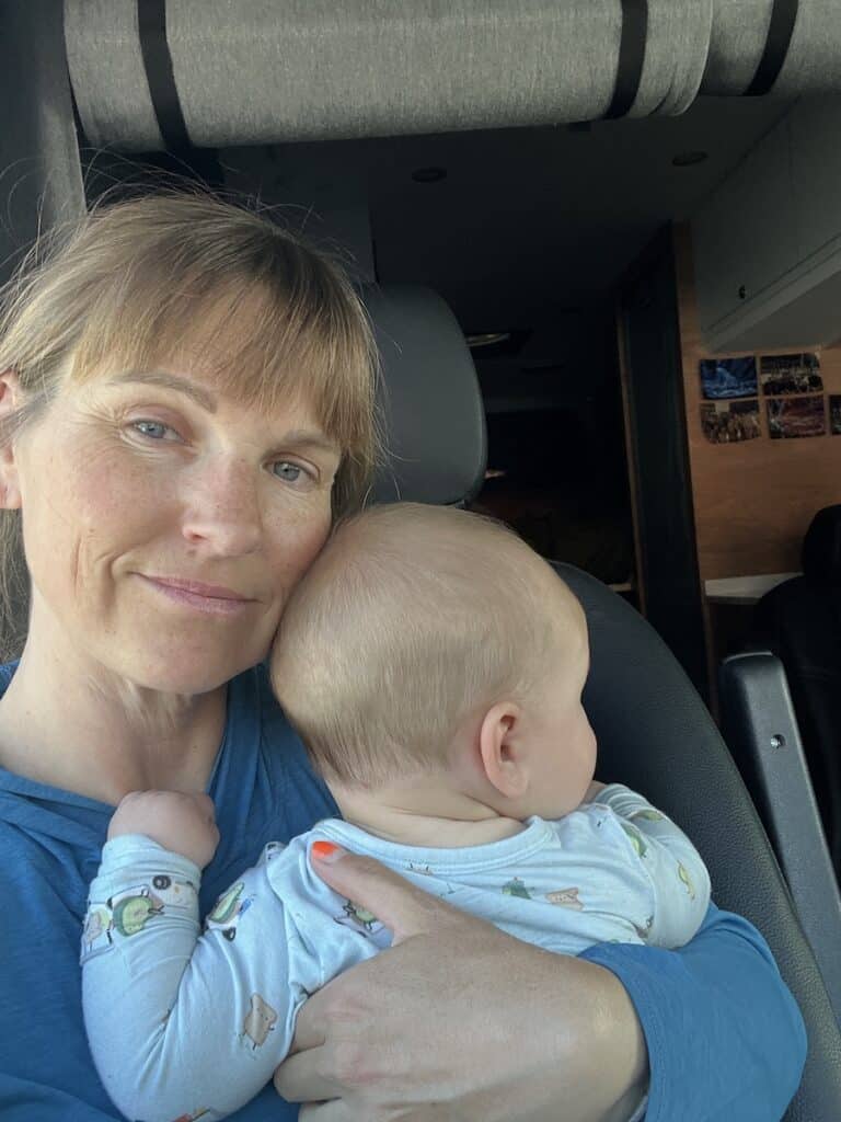 Woman holding baby in campervan