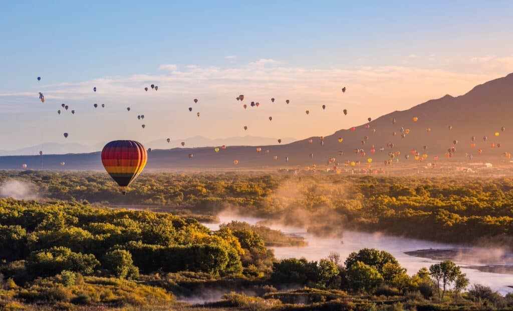 Dozens of hot air balloons in the sky during Albuquerque International Balloon Fiesta at sunrise