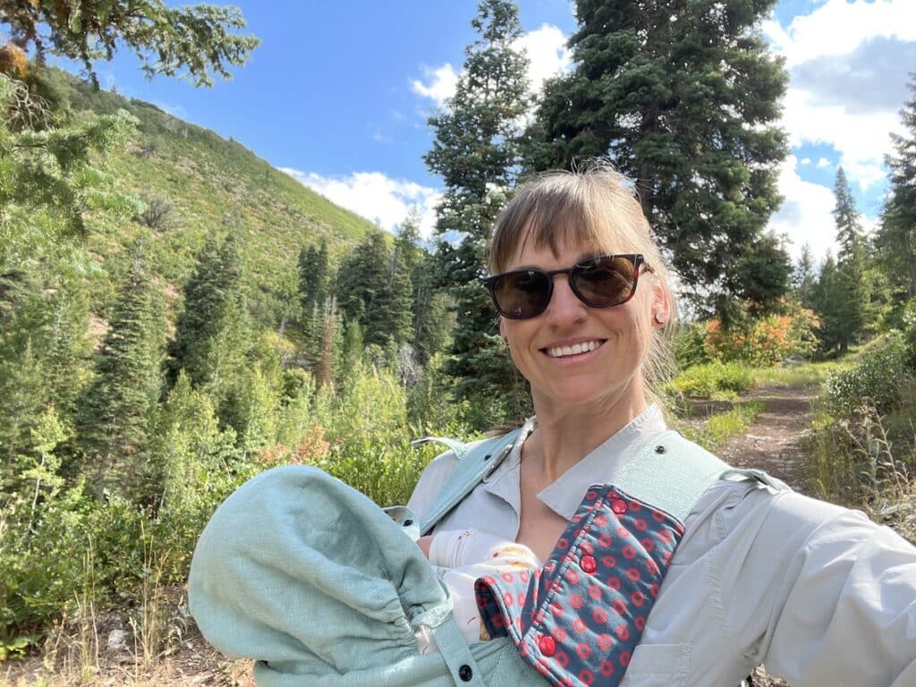 woman hiking with baby in baby carrier in park city utah