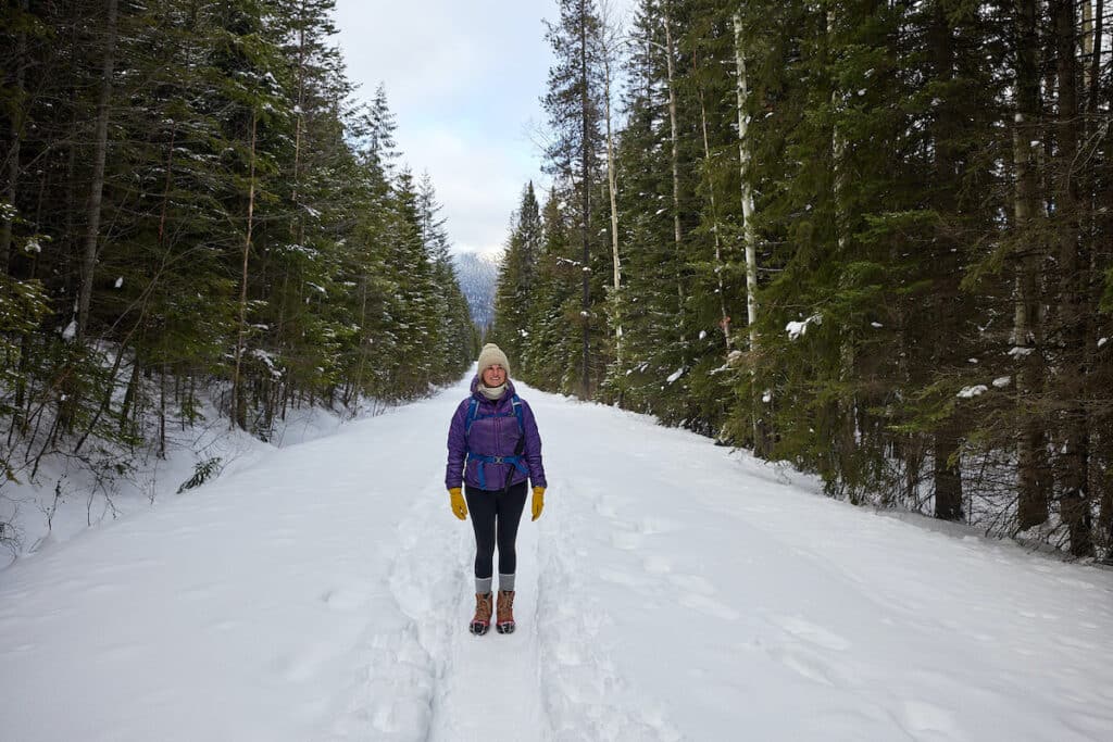 Women hiking on snowy trail in the forest to Wapta Falls in Yoho National Park