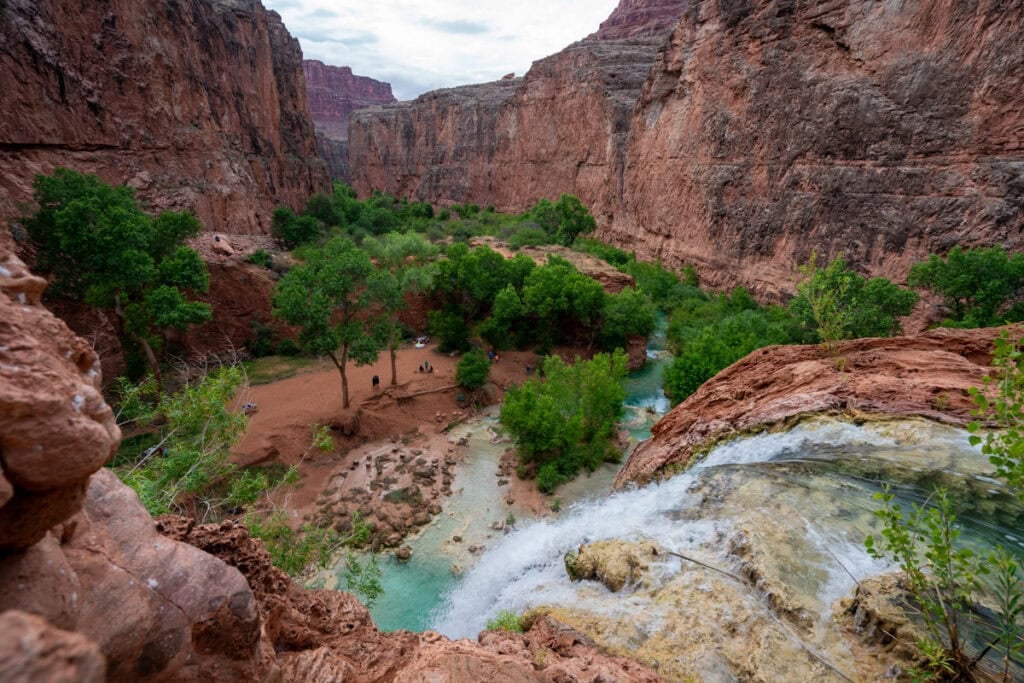 The top of Havasu Falls pouring down into a turquoise pool