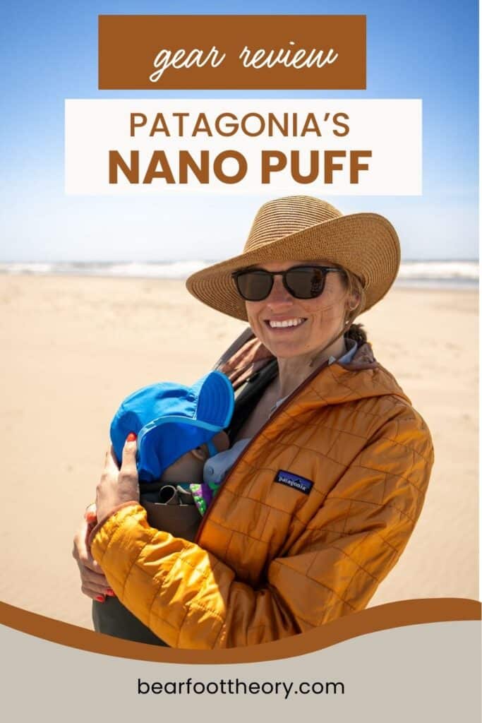 Pinnable image of woman smiling for photo on beach holding baby and dressed in warm jacket. Text reads "Gear Review: Patagonia Nano Puff"