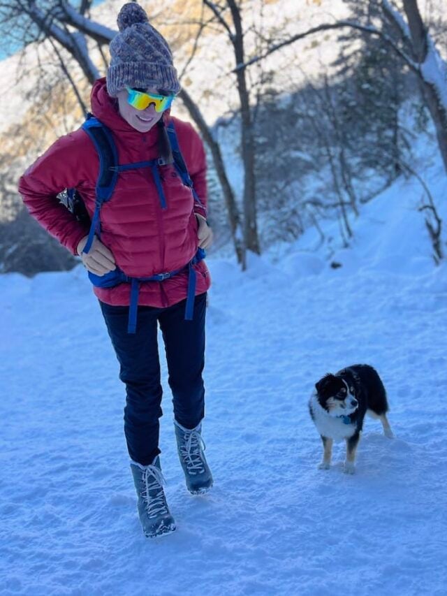 Bearfoot Theory founder Kristen Bor winter hiking with her mini aussie dog on a snowy trail in Utah