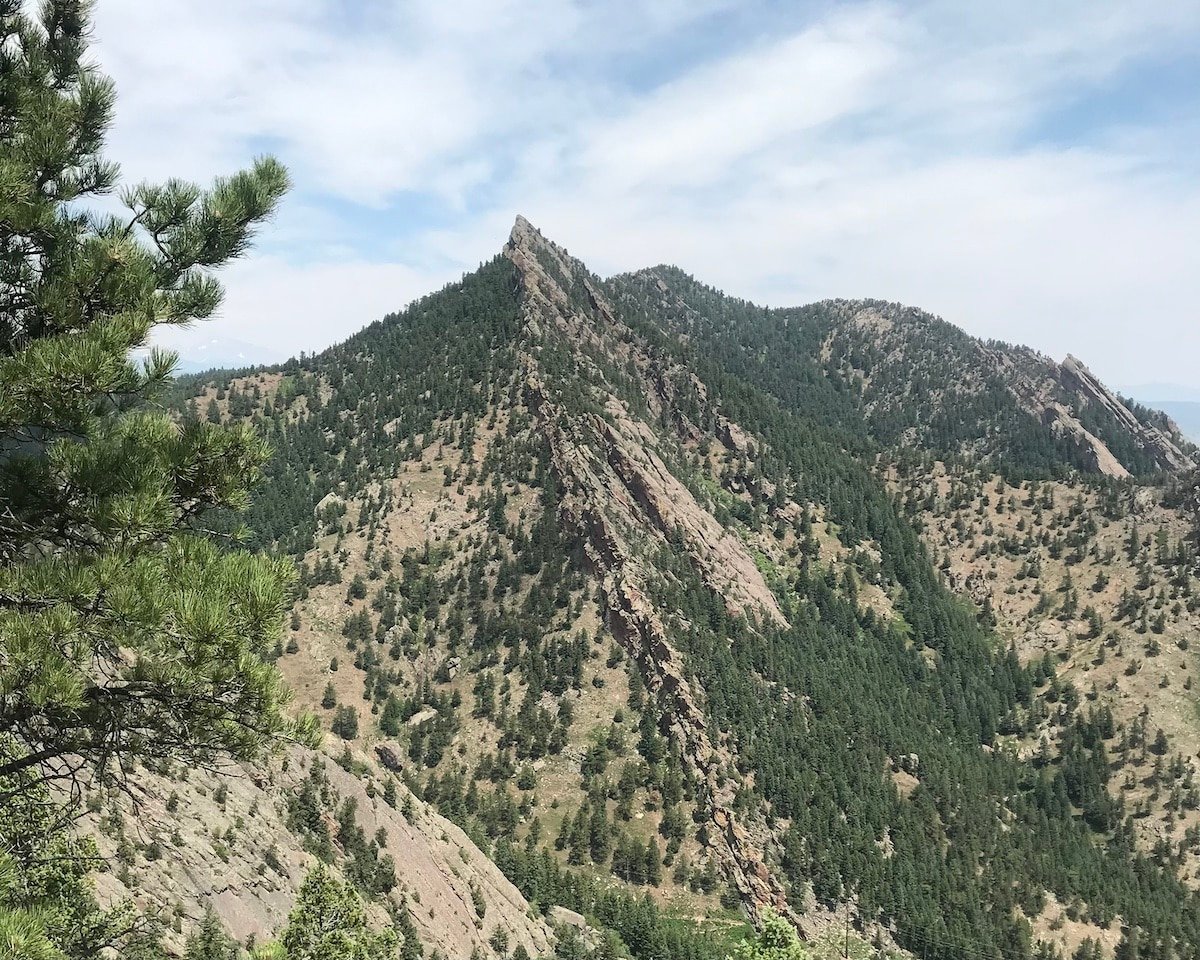 The view of the top of Bear Peak with rocks and trees from Bear Peak trail in Boulder, Colorado