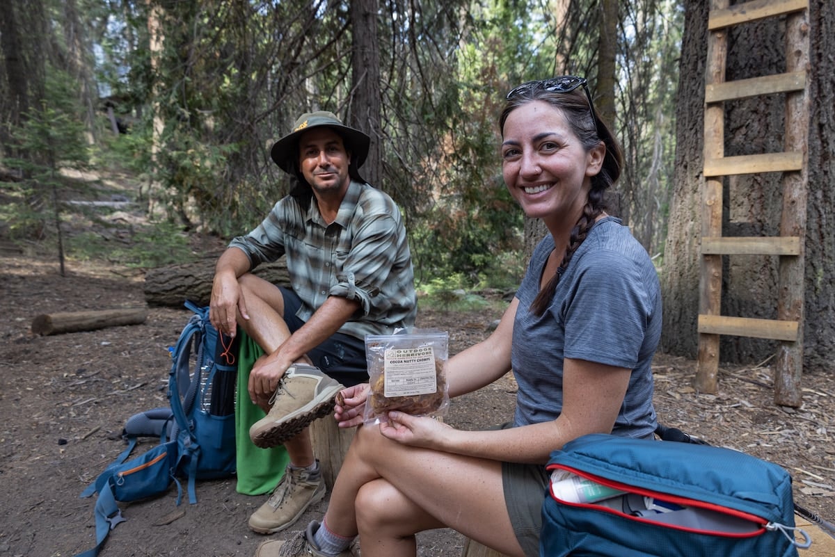 Couple eating snacks while resting on a hike