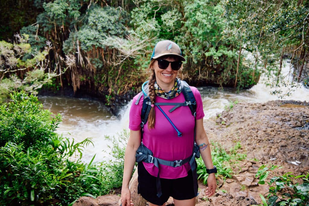 Woman smiling for photo in front of river on a hike in Maui