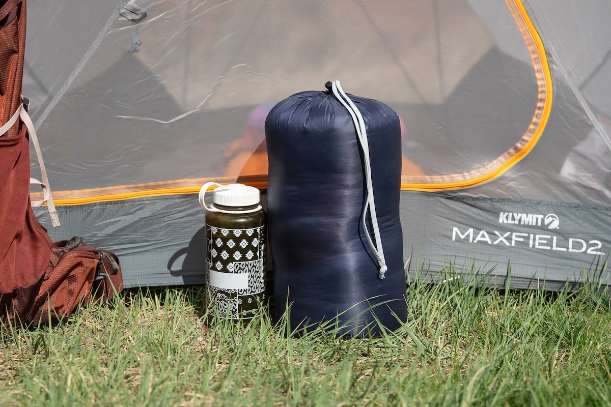 Size comparison of the REI Magma sleeping bag in its stuff sack next to a Nalgene water bottle