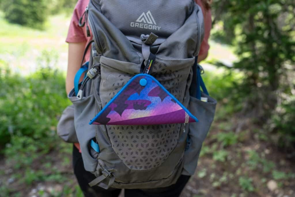 Kula Cloth pee rag hanging on the outside of a hiking backpack