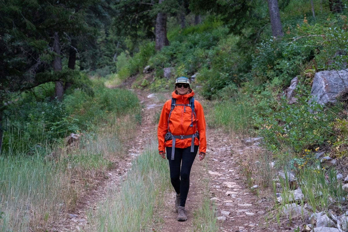 Kristen Bor wearing a red Arc'teryx Beta SL Rain Jacket on during a rainy hike.