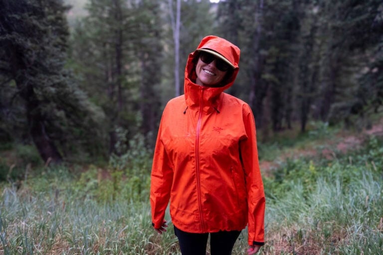 Kristen Bor wearing a red Arc'teryx Beta SL Rain Jacket with the hood on during a rainy hike