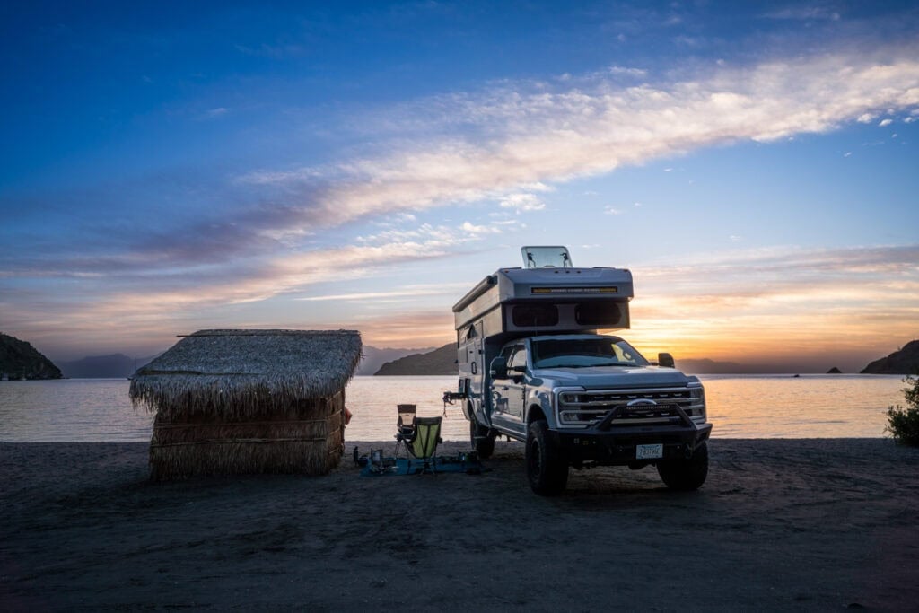 Rossmonster Baja Trail LX at a beachfront campsite at sunset in Baja next to a palapa