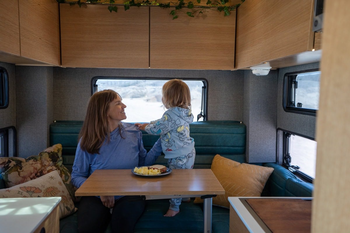 Kristen Bor and her son sitting in the dinette of the Rossmonster Baja Trail LX adventure truck camper