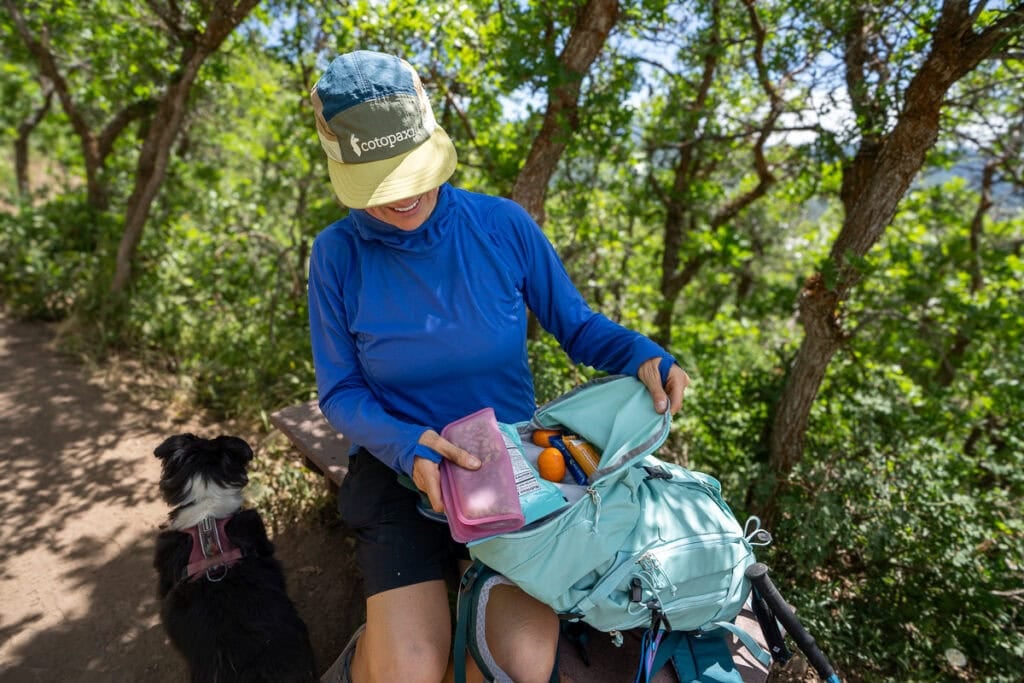 Kristen Bor getting snacks out of the lid on the deuter trail 28 sl hiking backpack